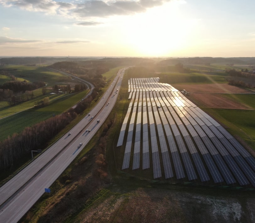 Feld mit Solaranlage entlang einer Autobahn