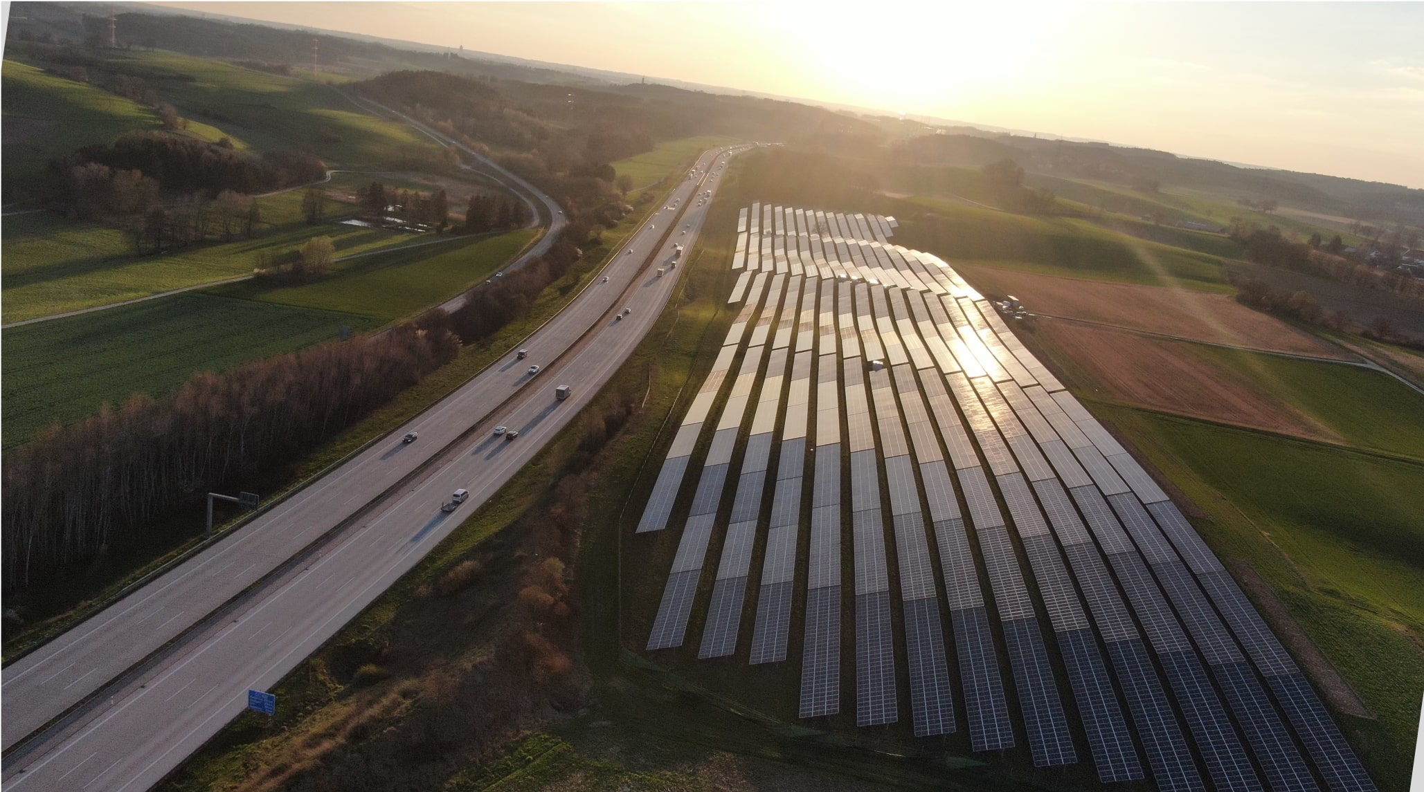 Feld mit Solaranlage entlang einer Autobahn