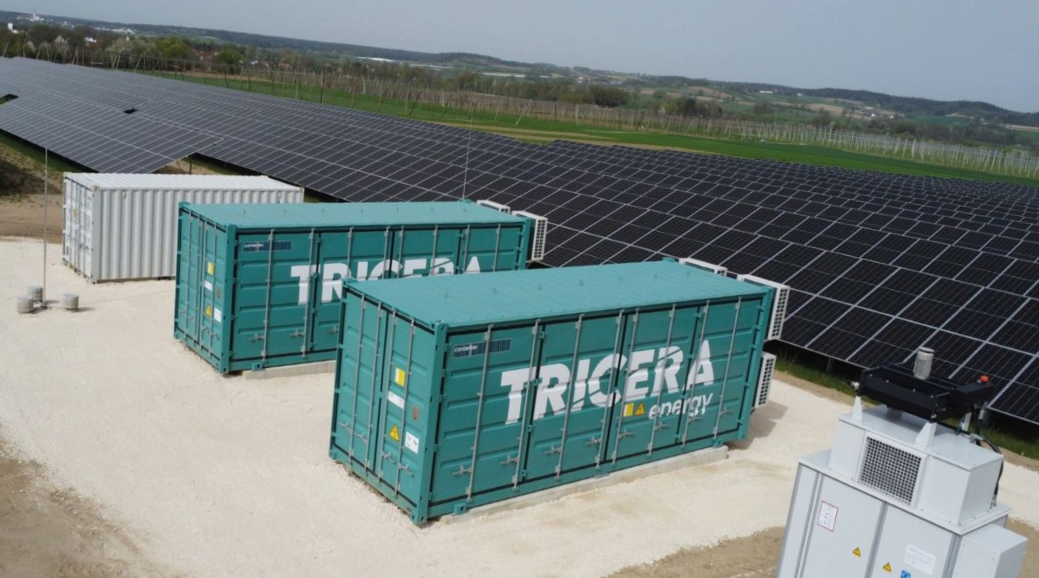 Ein Batteriespeicher von TRICERA energy steht an einer Photovoltaikanlage und speichert erzeugten Strom